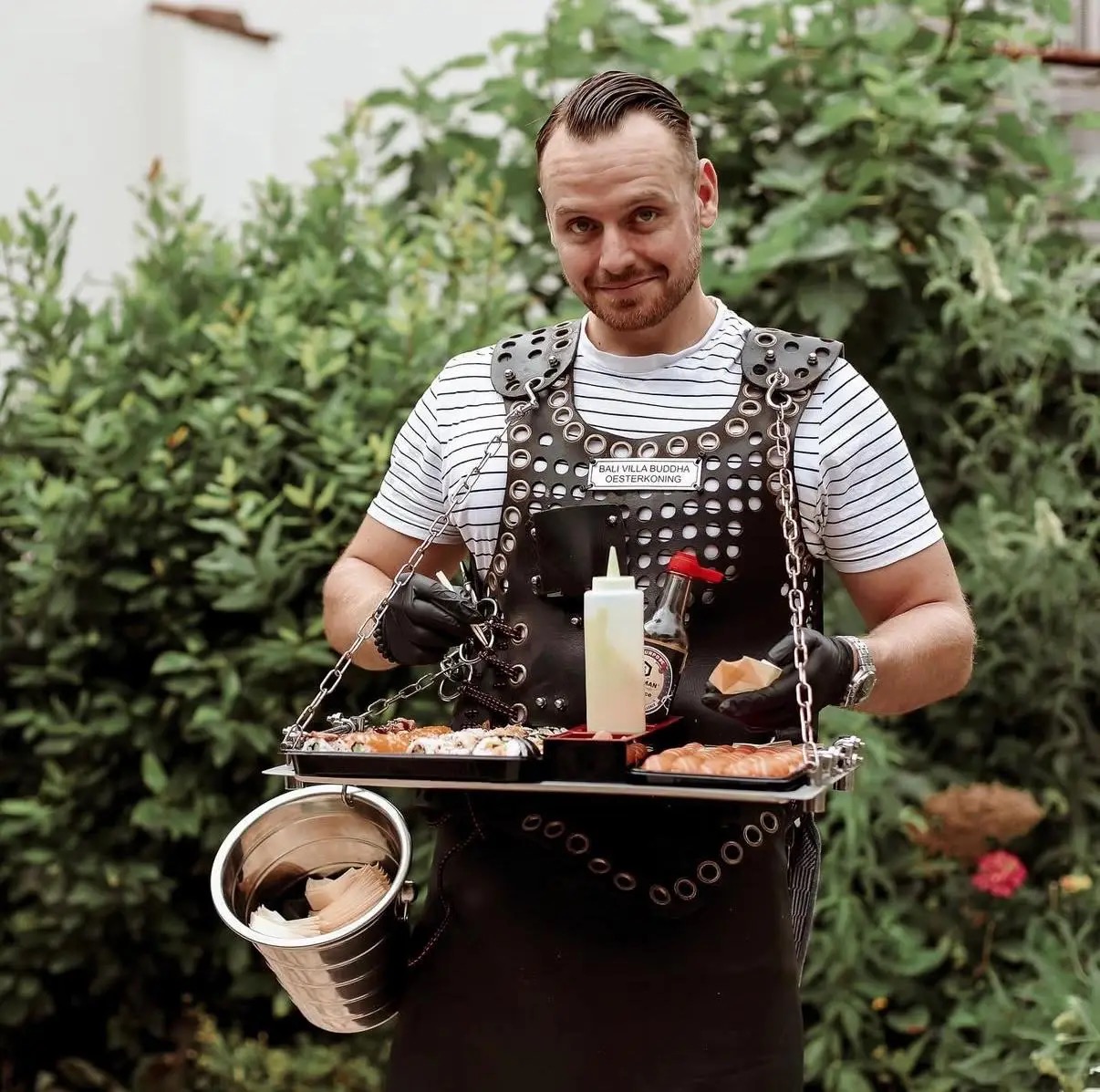 Sushikoning serveert een dienblad met verse sushi in de tuin.